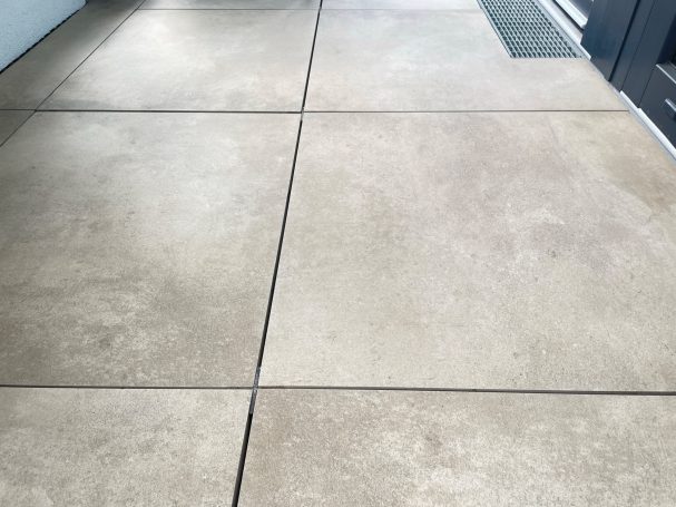 Geglätteter Betonboden mit klaren Fugen und Eingangstür im Hintergrund.